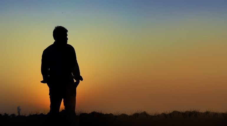 Silhouette of a man alone during sunset